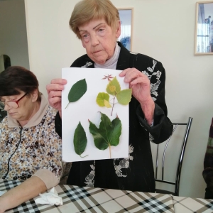 Постояльца пансионата демонстрируют свою аппликацию  из листьев  берёзы и вишни 