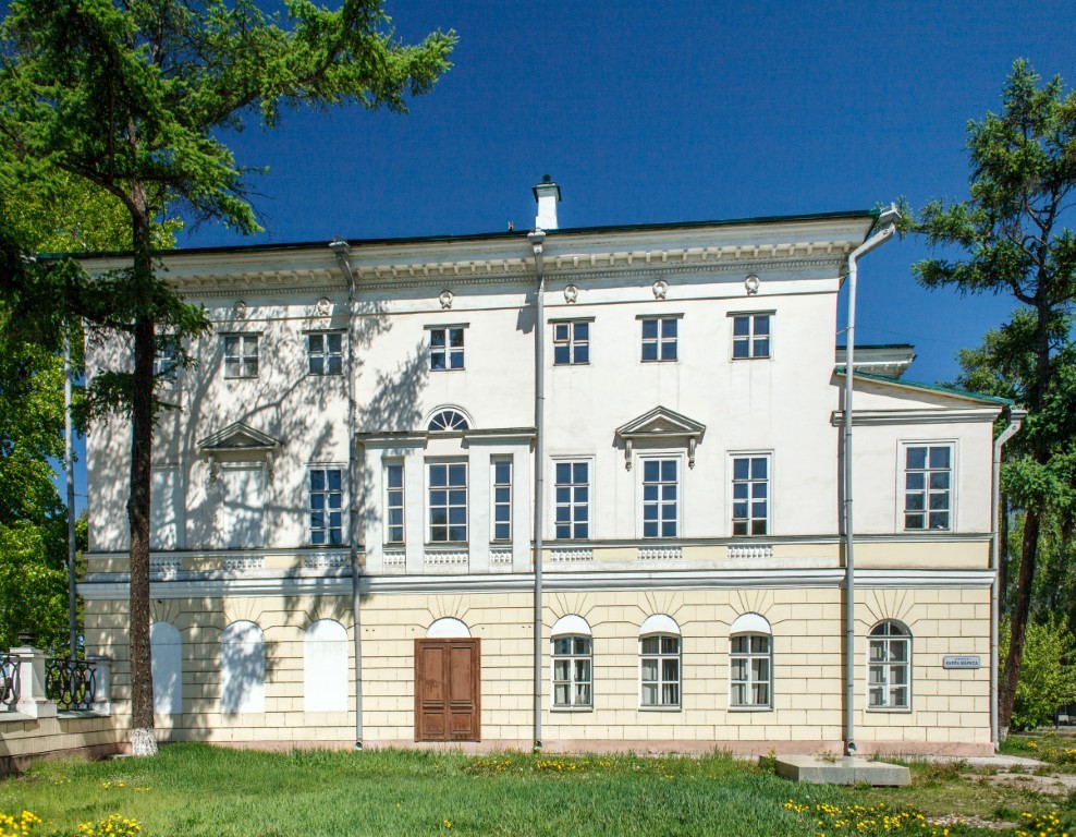 This photograph shows a classic, historic building with a light facade, which appears to be a public or institutional structure, possibly a hospital or school.